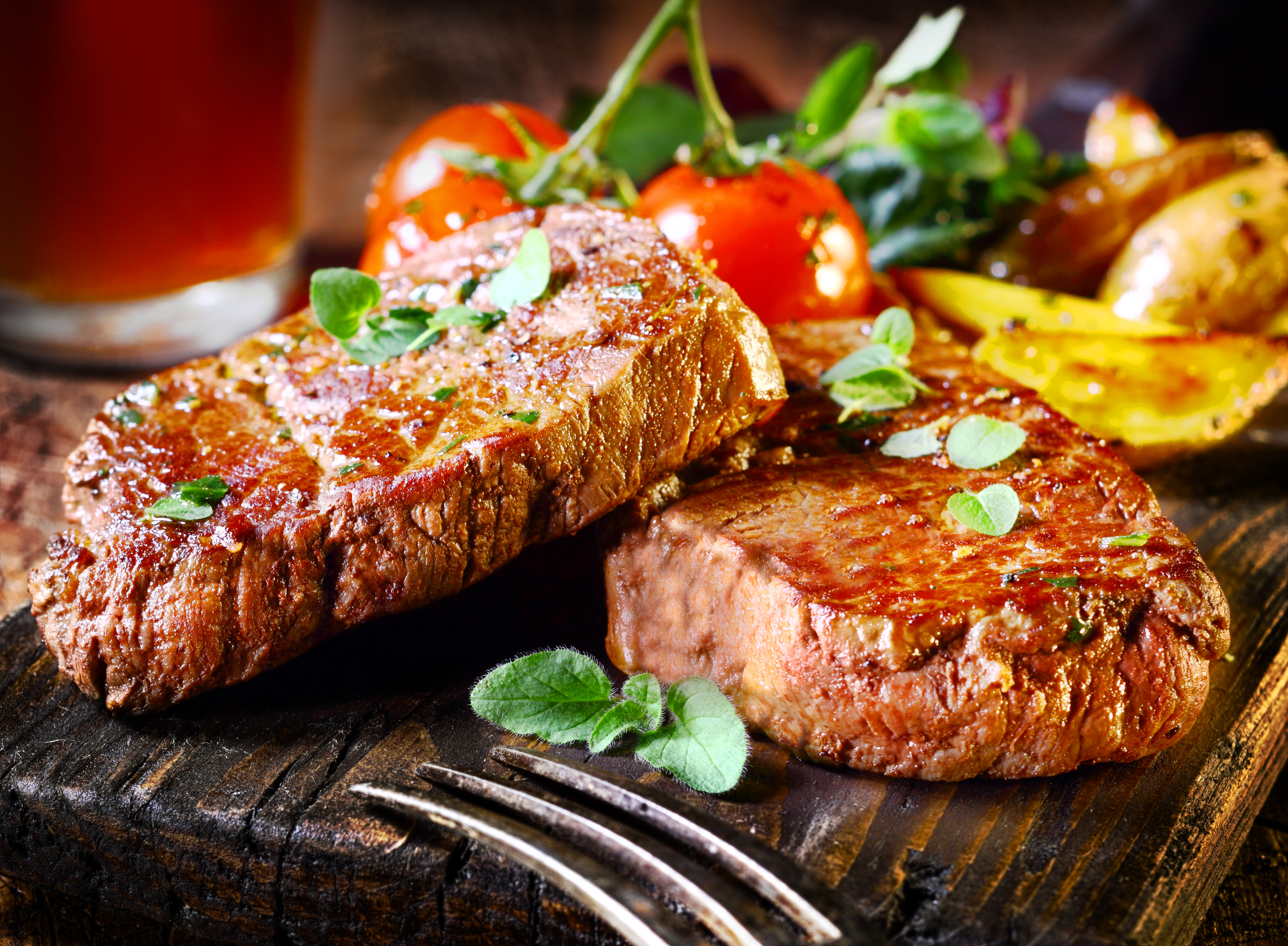 Steak served with roasted tomatoes and potatoes