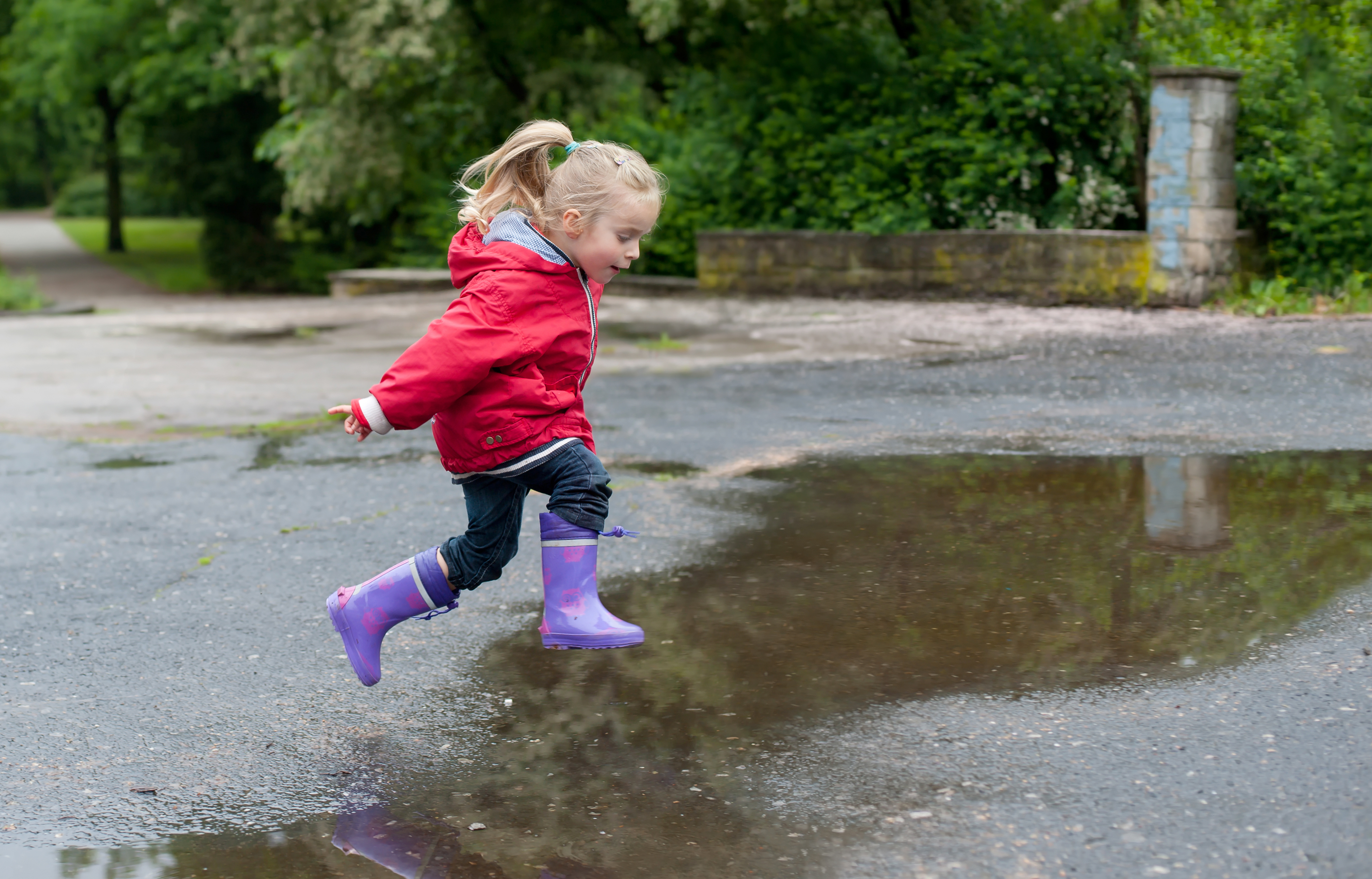 Kid jumping in the puddle in the rain