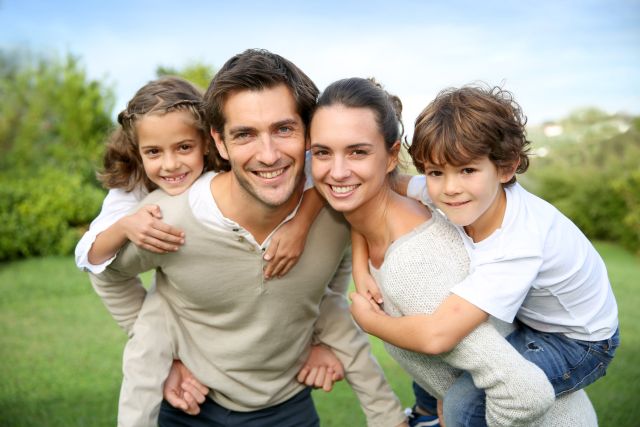 Parents giving their kids a piggy back ride